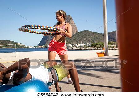 "Young woman holding plastic hoops, Rio de Janeiro, Brazil" View Large Photo Image Stock Image - "Young woman holding plastic hoops, Rio de Janeiro, Brazil". Fotosearch