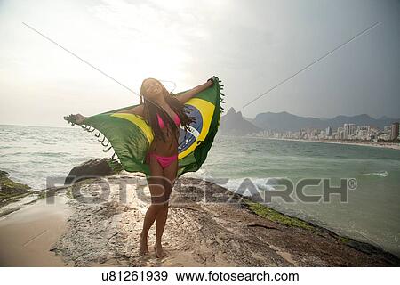 "Young woman holding up Brazilian flag, Ipanema beach, Rio De Janeiro, Brazil" View Large Photo Image Stock Photo - "Young woman holding up Brazilian flag, Ipanema beach, Rio De Janeiro, Brazil". Fotosearch