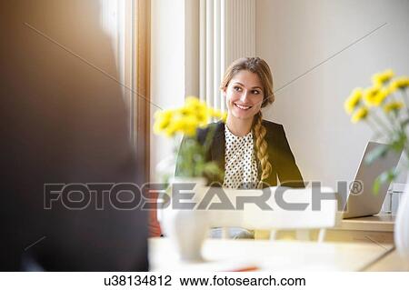 Stock Image - "Young woman in cafe, using laptop". Fotosearch