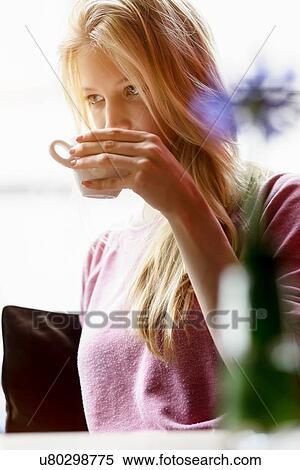Young woman in cafe window seat drinking coffee View Large Photo Image Stock Photography - Young woman in cafe window seat drinking coffee. Fotosearch