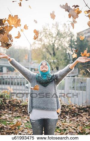 Young woman in park throwing autumn leaves View Large Photo Image Stock Photography - Young woman in park throwing autumn leaves. Fotosearch