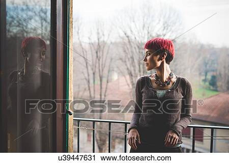 "Young woman leaning against balcony railings, looking at view" View Large Photo Image Stock Image - "Young woman leaning against balcony railings, looking at view". Fotosearch
