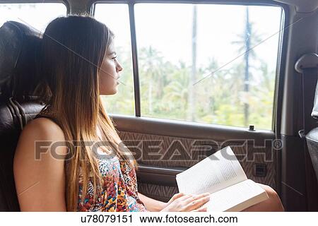 Stock Image - "Young woman looking out of taxi window, Tagbilaran, Bohol Province, Philippines". Fotosearch