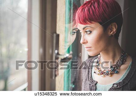"Young woman looking out of window, pensive expression" View Large Photo Image Stock Photography - "Young woman looking out of window, pensive expression". Fotosearch