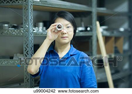 Young woman looking through metal tube in industrial workshop View Large Photo Image Stock Image - Young woman looking through metal tube in industrial workshop. Fotosearch