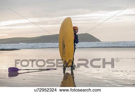 "Young woman on beach with sea kayak, Polzeath, Cornwall, England" View Large Photo Image Picture - "Young woman on beach with sea kayak, Polzeath, Cornwall, England". Fotosearch