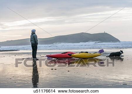 "Young woman on beach with sea kayaks, Polzeath, Cornwall, England" View Large Photo Image Picture - "Young woman on beach with sea kayaks, Polzeath, Cornwall, England". Fotosearch