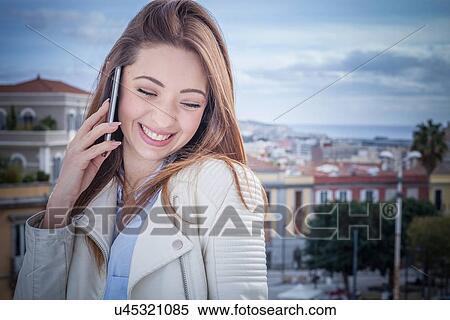 "Young woman on rooftop chatting on smartphone, Cagliari, Sardinia, Italy" View Large Photo Image Stock Photography - "Young woman on rooftop chatting on smartphone, Cagliari, Sardinia, Italy". Fotosearch