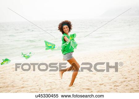 "Young woman playing with string of flags on beach, Rio de Janeiro, Brazil" View Large Photo Image Stock Photography - "Young woman playing with string of flags on beach, Rio de Janeiro, Brazil". Fotosearch