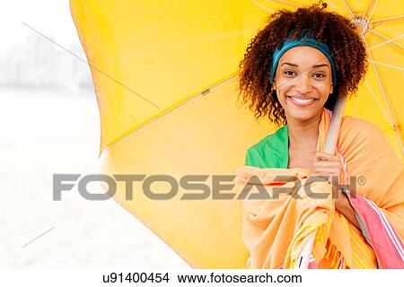 Young woman posing with umbrella on beach View Large Photo Image Picture - Young woman posing with umbrella on beach. Fotosearch