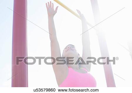Young woman reaching for exercise bar View Large Photo Image Stock Image - Young woman reaching for exercise bar. Fotosearch