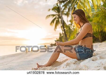 "Young woman reading smartphone texts on Anda beach, Bohol Province, Philippines" View Large Photo Image Stock Photo - "Young woman reading smartphone texts on Anda beach, Bohol Province, Philippines". Fotosearch