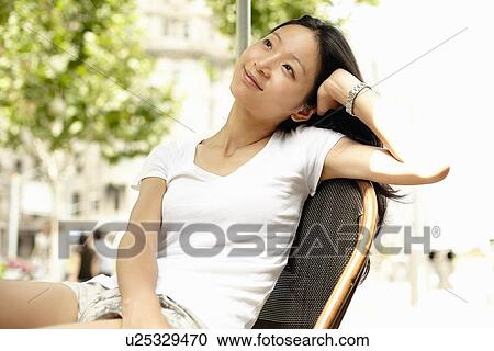 "Young woman resting on elbow and looking up at sidewalk cafe, The Bund, Shanghai, China" View Large Photo Image Stock Image - "Young woman resting on elbow and looking up at sidewalk cafe, The Bund, Shanghai, China". Fotosearch