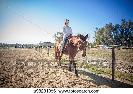 Young woman riding horse View Large Photo Image Stock Photograph - Young woman riding horse. Fotosearch