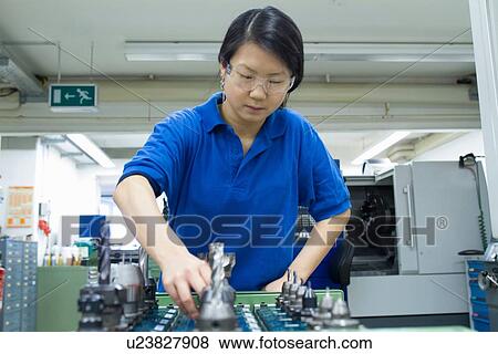 Young woman selecting metal components in industrial workshop View Large Photo Image Stock Photo - Young woman selecting metal components in industrial workshop. Fotosearch