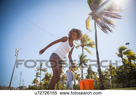 Stock Photography - "Young woman skateboarding along street, low angle view". Fotosearch