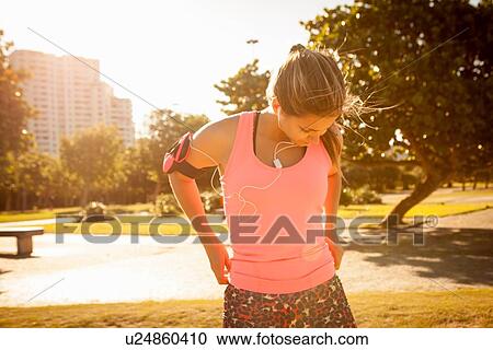 Young woman training wearing earphones in park View Large Photo Image Stock Image - Young woman training wearing earphones in park. Fotosearch