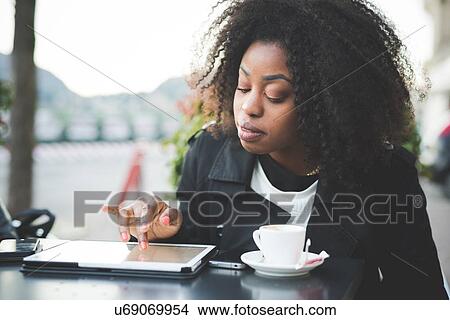 "Young woman using digital tablet at sidewalk cafe, Lake Como, Como, Italy" View Large Photo Image Picture - "Young woman using digital tablet at sidewalk cafe, Lake Como, Como, Italy". Fotosearch