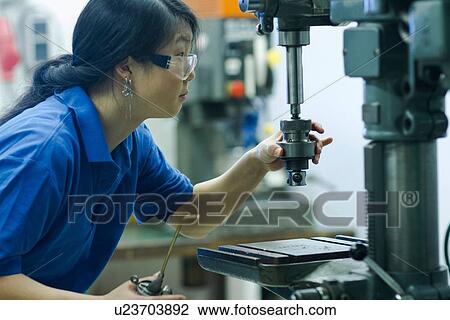 Young woman using drill in industrial workshop View Large Photo Image Stock Image - Young woman using drill in industrial workshop. Fotosearch