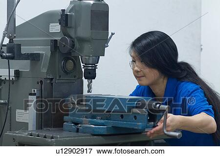 Young woman using drill in industrial workshop View Large Photo Image Stock Photo - Young woman using drill in industrial workshop. Fotosearch