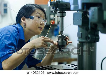 Young woman using drill in industrial workshop View Large Photo Image Stock Photograph - Young woman using drill in industrial workshop. Fotosearch