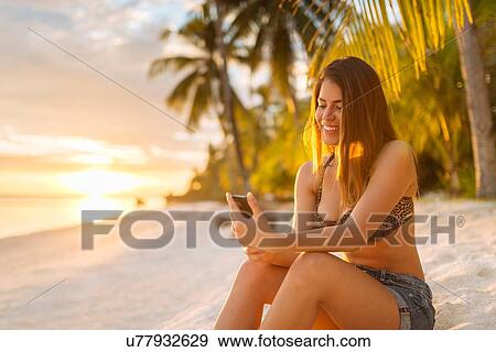 "Young woman using smartphone on Anda beach, Bohol Province, Philippines" View Large Photo Image Stock Photo - "Young woman using smartphone on Anda beach, Bohol Province, Philippines". Fotosearch