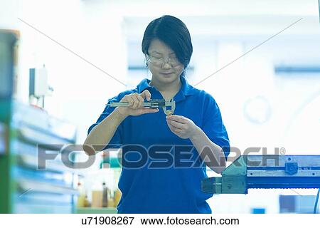 Young woman using specialist measuring device View Large Photo Image Stock Photo - Young woman using specialist measuring device. Fotosearch
