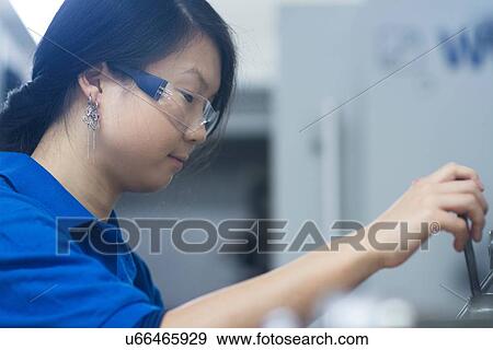 Young woman wearing safety glasses in industrial workshop View Large Photo Image Stock Photo - Young woman wearing safety glasses in industrial workshop. Fotosearch
