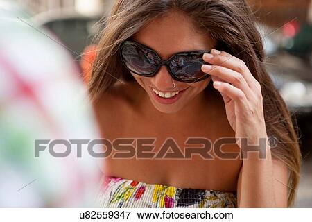 Stock Photo - "Young woman wearing sunglasses on street, Copacabana town, Rio De Janeiro, Brazil". Fotosearch