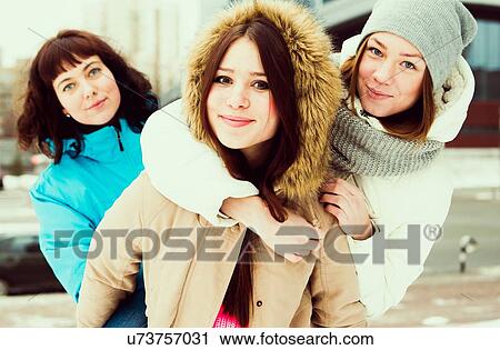 Young woman wearing winter coat with friends View Large Photo Image Stock Image - Young woman wearing winter coat with friends. Fotosearch
