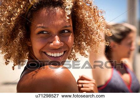 Young woman with curly hair looking over shoulder View Large Photo Image Stock Photo - Young woman with curly hair looking over shoulder. Fotosearch