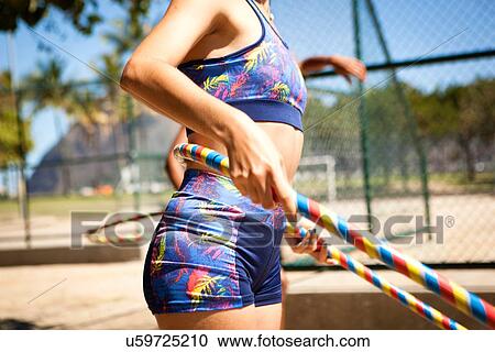 "Young woman with hula hoop around waist, outdoors" View Large Photo Image Stock Image - "Young woman with hula hoop around waist, outdoors". Fotosearch