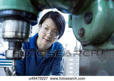 Young woman working in industrial workshop View Large Photo Image Stock Photo - Young woman working in industrial workshop. Fotosearch