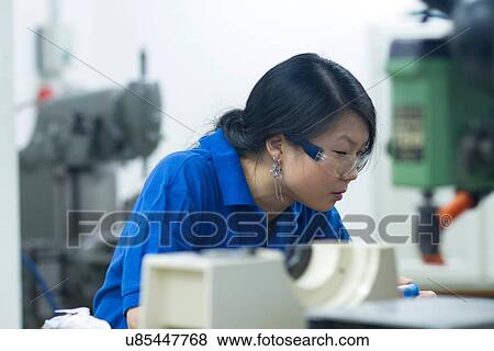 Young woman working in industrial workshop View Large Photo Image Stock Photo - Young woman working in industrial workshop. Fotosearch