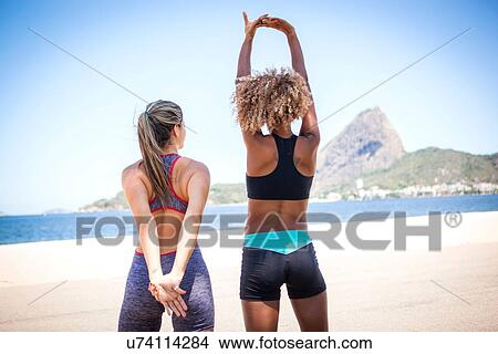 "Young women stretching on beach, Rio de Janeiro, Brazil" View Large Photo Image Picture - "Young women stretching on beach, Rio de Janeiro, Brazil". Fotosearch