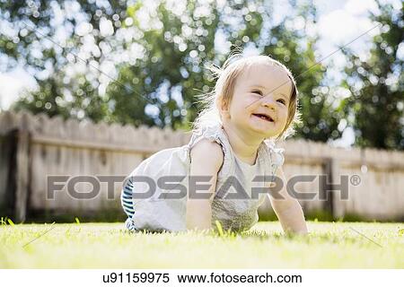 Baby girl (6-11 months) laughing in backyard View Large Photo Image Stock Photography - Baby girl (6-11 months) laughing in backyard. Fotosearch