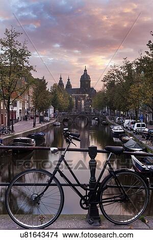 Basilica of st nicholas and bicycle by canal in city View Large Photo Image Picture - Basilica of st nicholas and bicycle by canal in city. Fotosearch