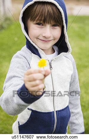 Stock Photo - Boy (6-7) holding dandelion. Fotosearch