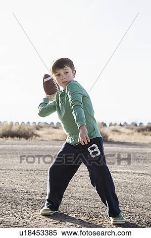 Stock Photography - Boy (6-7) playing football. Fotosearch