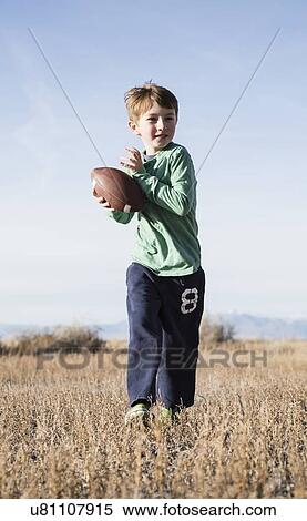 Stock Photography - Boy (6-7) playing football. Fotosearch
