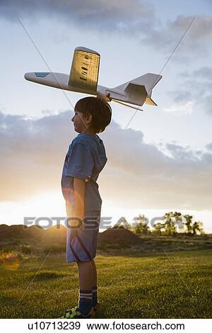 Boy (6-7) playing with model airplane outdoors View Large Photo Image Stock Photo - Boy (6-7) playing with model airplane outdoors. Fotosearch