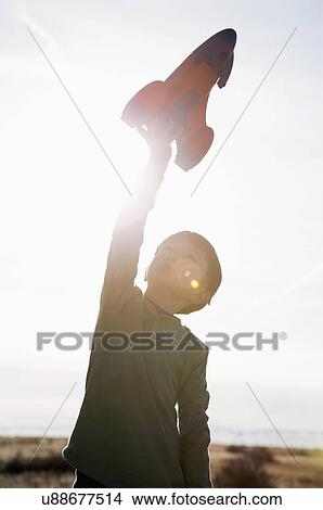 Picture - Boy (6-7) playing with toy rocket. Fotosearch