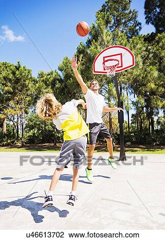 Boy (8-9) playing basketball with his brother View Large Photo Image Stock Image - Boy (8-9) playing basketball with his brother. Fotosearch