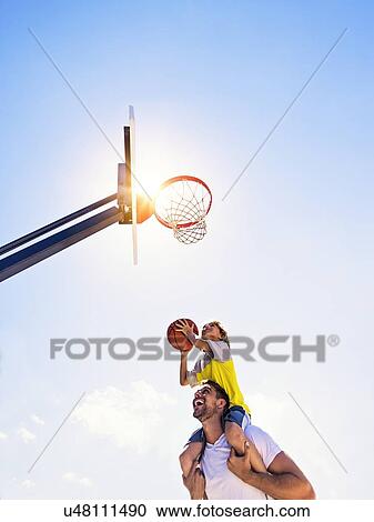 Boy (8-9) playing basketball with his brother View Large Photo Image Stock Image - Boy (8-9) playing basketball with his brother. Fotosearch