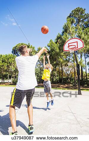 Boy (8-9) playing basketball with his brother View Large Photo Image Stock Photo - Boy (8-9) playing basketball with his brother. Fotosearch