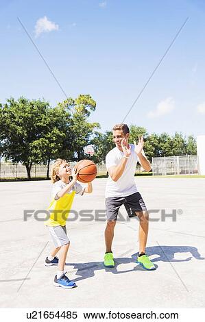 Boy (8-9) playing basketball with his brother View Large Photo Image Stock Photography - Boy (8-9) playing basketball with his brother. Fotosearch