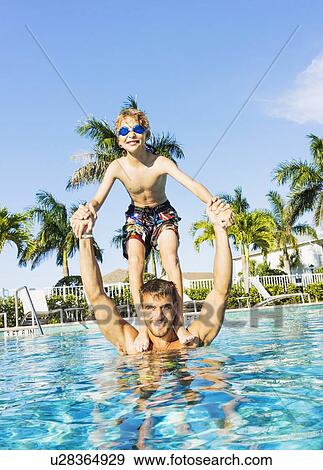 Boy (8-9) standing on brother's shoulders View Large Photo Image Stock Photo - Boy (8-9) standing on brother's shoulders. Fotosearch