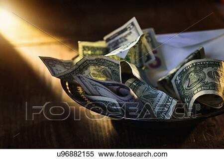 Stock Photography - Close up of banknotes on collection plate. Fotosearch