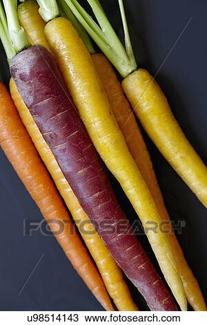 Stock Image - Colorful carrots on black background. Fotosearch