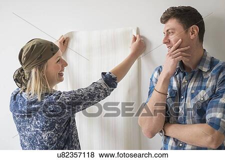 Couple choosing wallpaper for house View Large Photo Image Stock Photo - Couple choosing wallpaper for house. Fotosearch